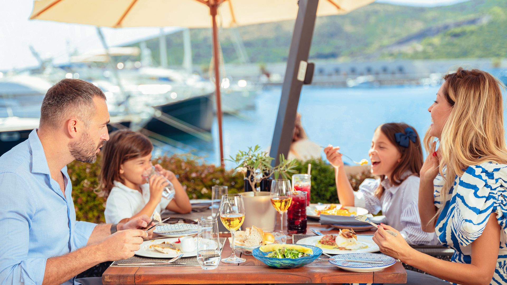 a family enjoying a food and drinks inside the chedi lustica bay hotel with sea view