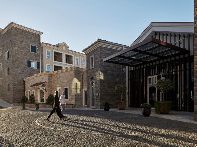 A Person Walking In A Courtyard Between Buildings